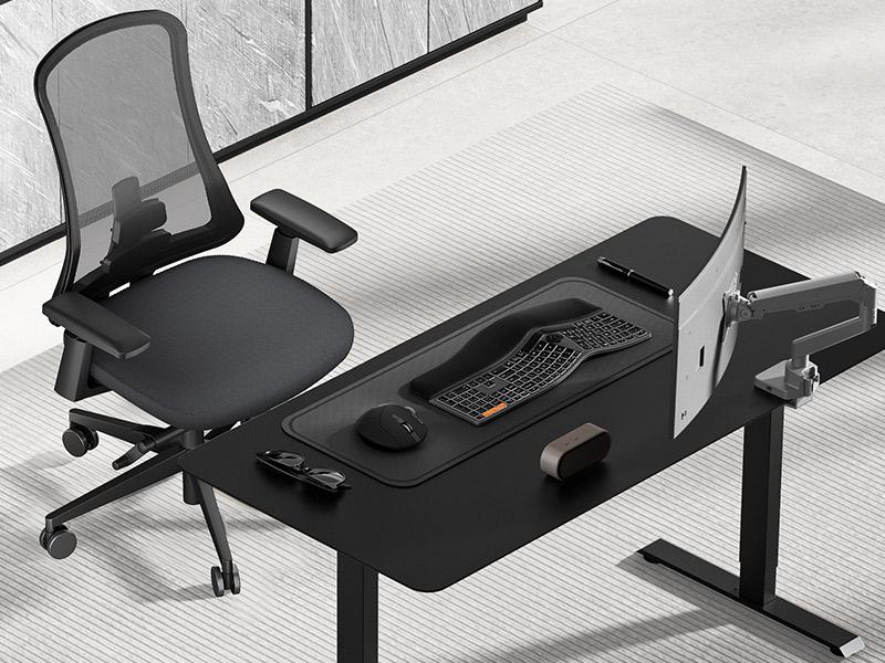 Ergonomic black office chair at a black standing desk with curved monitor
