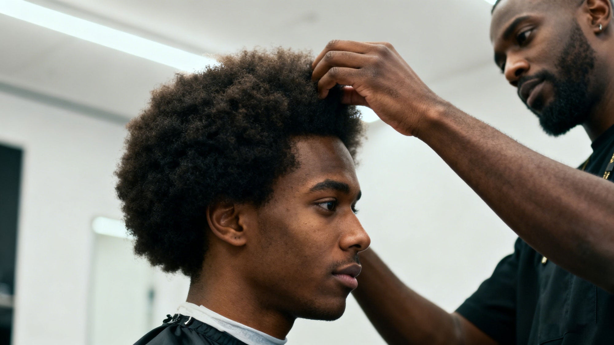 Afro hairstyle being styled by barber. Men's hair styling and care