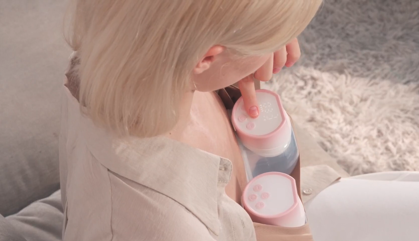 Woman using hands-free, wearable breast pump for milk expression