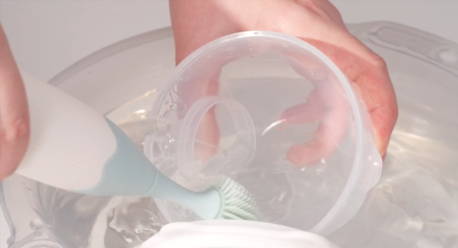 Cleaning breast pump parts with soft bristle brush in soapy water