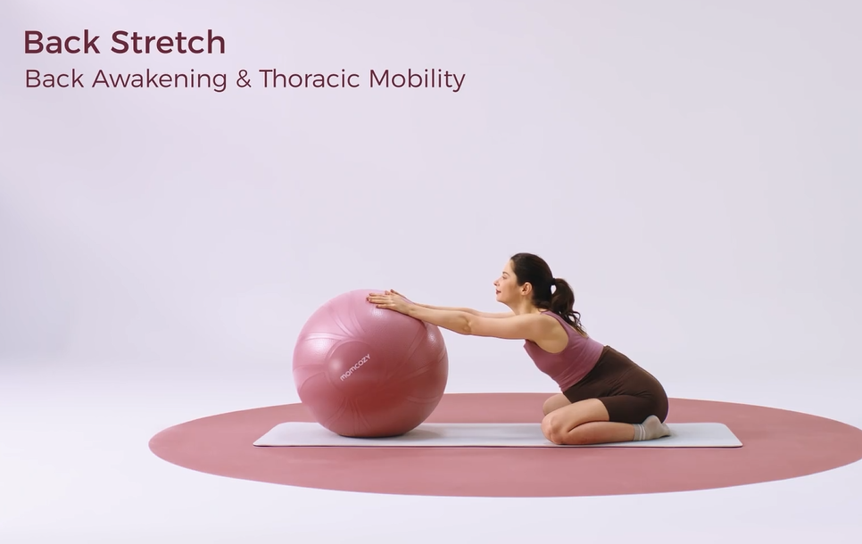 Woman performing kneeling back stretch on stability ball for thoracic mobility